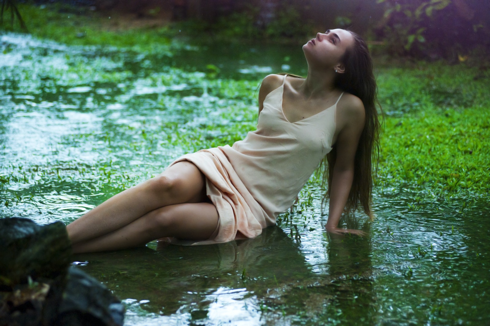 Woman Lying on Wet Grass Field