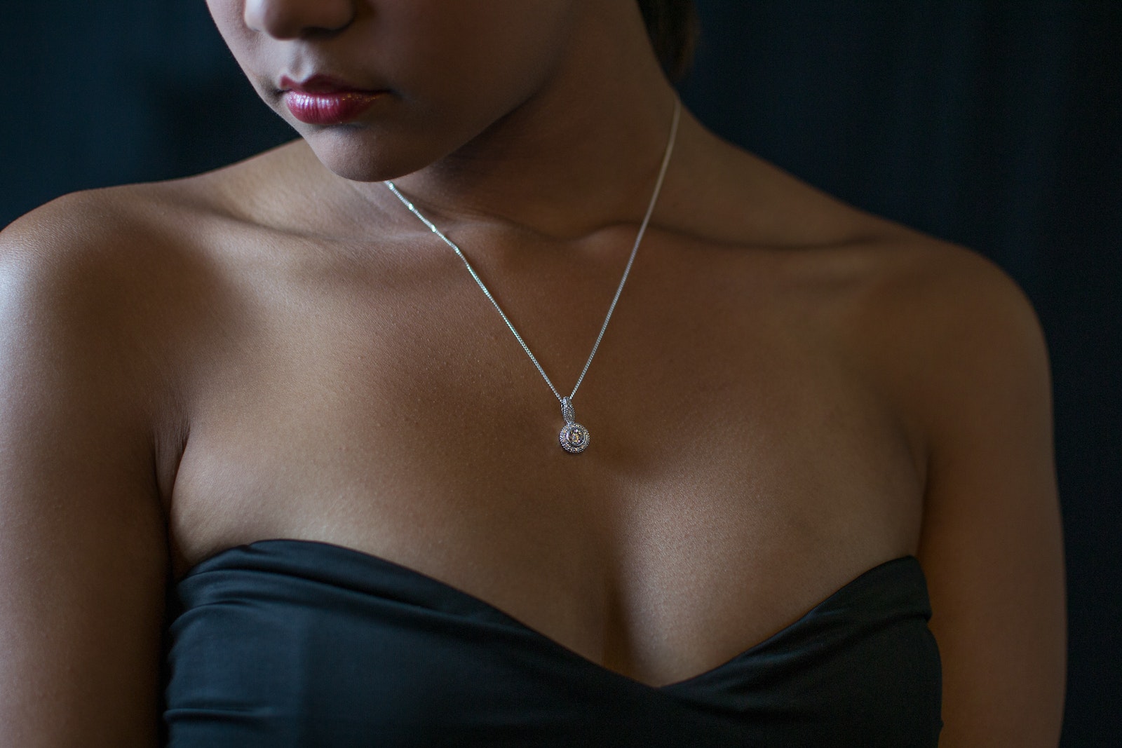Woman in Black Strapless Top Wearing Gold Necklace