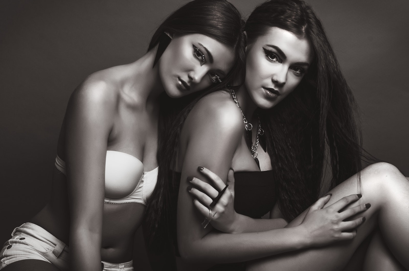 Two Woman Wearing Black and White Brassiere